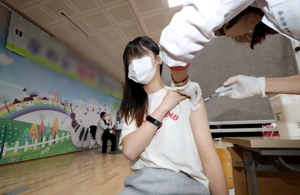 지난해 12월 한 학교에서 재학생들이 백신 접종을 받고 있다. 		 /뉴시스