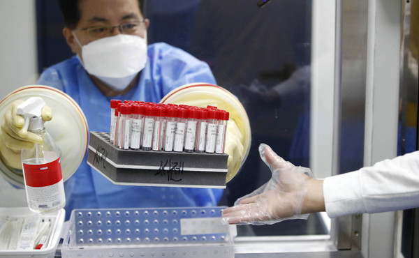 광주 북구 선별진료소에서 보건소 의료진이 PCR 진단 검사 검체통을 운반하고 있다. 							 /북구보건소 제공