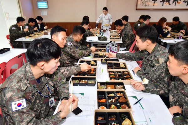 장성군과 ㈜더본코리아가 최근 상무대에서 개최한 ‘군급식 품평회’에서 장병들이 장성산 식재료로 만든 음식을 맛보고 있다.                                                    /장성군 제공