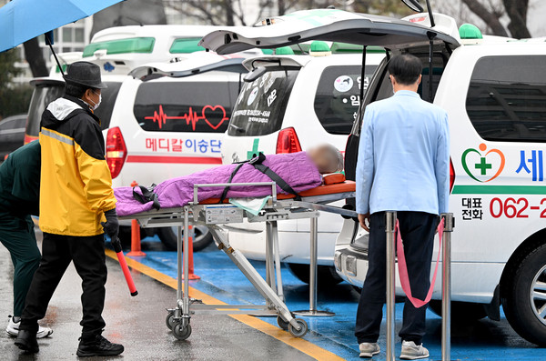 전공의 집단 이탈이 시작된 지 사흘째인 지난 21일 오전 광주 동구 조선대학교병원에서 퇴원 수속을 밟은 환자가 인근 병원으로 옮겨지고 있다.  											           /뉴시스