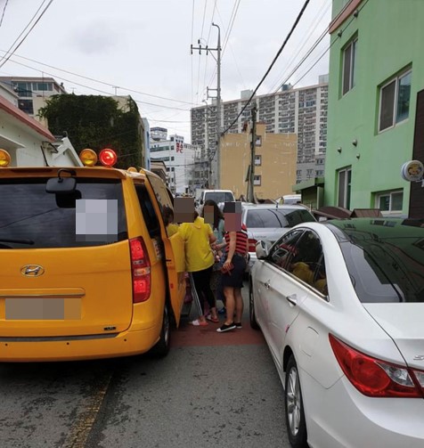 목포시의원의 불법주차로 어린이집 원생들이 도로로 걸어나가 차량에 탑승하고 있다.