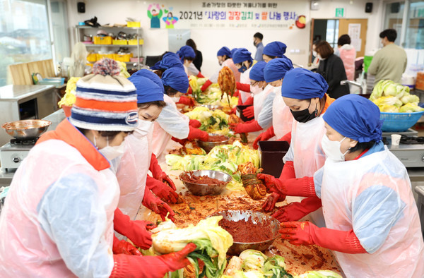 사랑의 김장김치 및 쌀 나눔 행사에 참여하고 있는 강진군여성단체협의회원들.