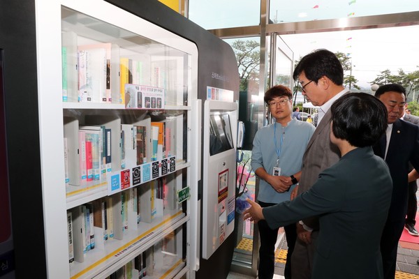 김성 장흥군수(오른쪽 두번째)가 스마트도서관 이용방법에 대해 설명을 듣고 있다.                                                                                                            /장흥군 제공